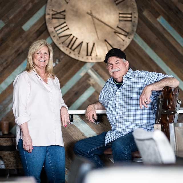 A man and woman sitting at a counter, posing for a photo